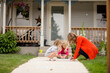 © Jennifer Bogle/Stocksy - Mother draws with chalk on front walk