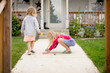 © Jennifer Bogle/Stocksy - Girl draws with sidewalk chalk on front path