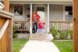 © Jennifer Bogle/Stocksy - Mother watches girls play on front path
