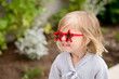 © Jennifer Bogle/Stocksy - Smiling girl with star sunglasses