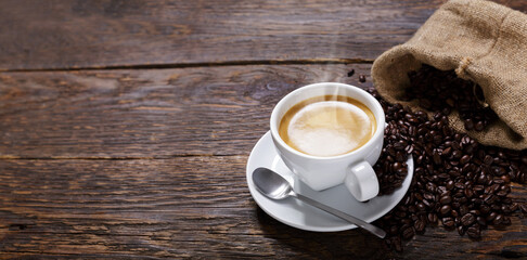 Wall Mural - cup of coffee and coffee beans on a wooden table