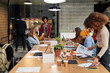 © Guille Faingold/Stocksy - Colleagues preparing for meeting in office