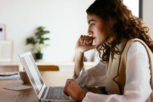 Female Employee Thinking Over Data On Laptop