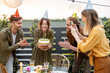 © rh2010 - Young adult friends celebrating birthday, having fun blowing candles on a cake at backyard of a country house outdoors