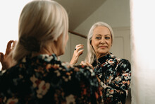 Senior Woman Combing Her Hair Looking At Mirror Before Go To Work