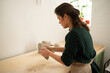 © Malquerida Studio/Stocksy - Ceramist young woman preparing clay to make pottery pieces in her studio
