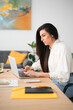 © Studio Marmellata/Stocksy - Focused female working on laptop in office
