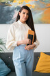 © Studio Marmellata/Stocksy - Woman in Arab formal wear standing with notepad in office