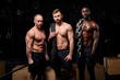 © Roman - three diverse shirtless sportsmen with cross fit equipment posing at camera, having muscular body, engaged in workout training