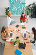 © Studio Marmellata/Stocksy - Diverse female colleagues discussing business strategy at table in workspace