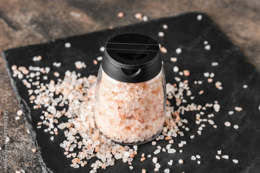 Jar with sea salt on grunge background