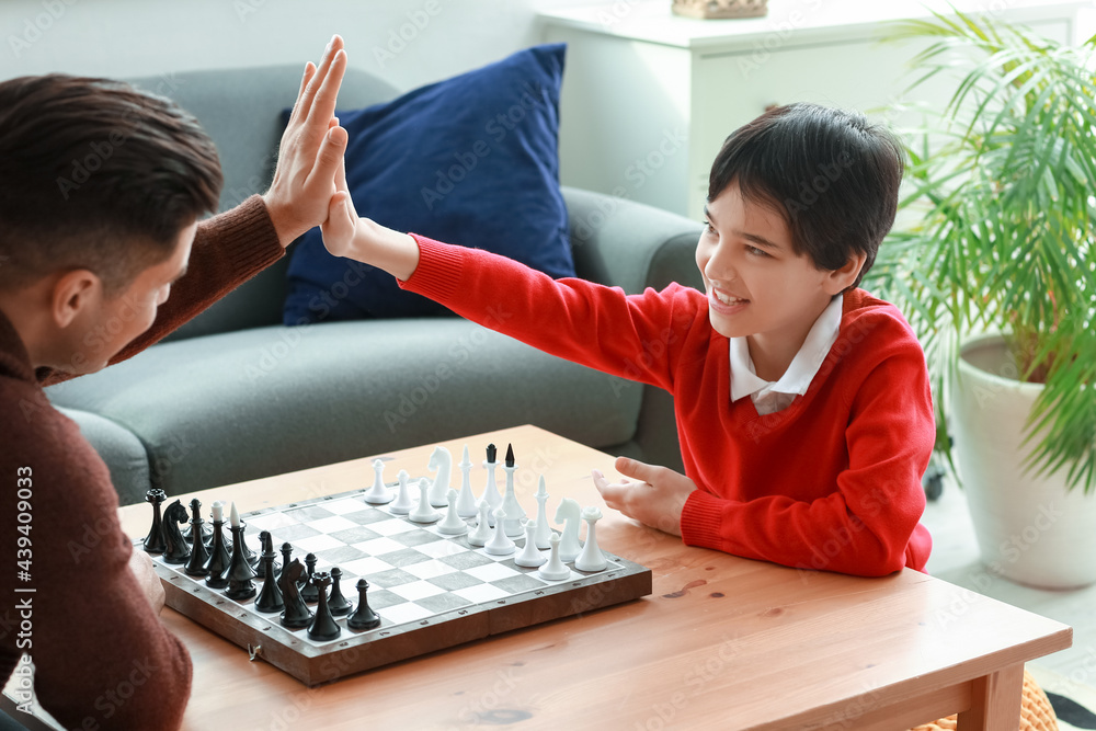 Father and son playing chess at home