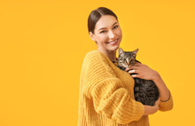 Beautiful Young Woman With Cute Cat On Color Background