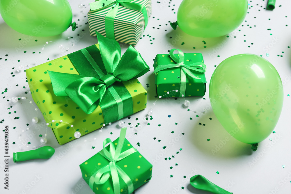 Air balloons, gift boxes and confetti on grey background