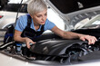 © Roman - Cute Female auto mechanic examine car engine breakdown problem in front of automotive vehicle car hood. Safety technical inspection care check service maintenance for customer before long road trip