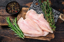 Raw Sliced Cut Chicken Breast Fillet Cutlets On A Wooden Cutting Board With Cleaver. Dark Wooden Background. Top View