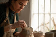 © Malquerida Studio/Stocksy - Ceramist young woman Making Clay cups  in her studio