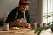 © Malquerida Studio/Stocksy - Ceramist young woman Making Clay cups  in her studio
