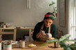 © Malquerida Studio/Stocksy - Ceramist young woman Making Clay cups  in her studio