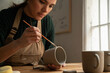 © Malquerida Studio/Stocksy - Ceramist young woman Making Clay cups  in her studio