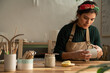 © Malquerida Studio/Stocksy - Ceramist young woman Making Clay cups  in her studio