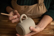© Malquerida Studio/Stocksy - Close up of ceramist woman Making Clay cups  in her studio