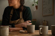 © Malquerida Studio/Stocksy - Ceramist young woman Making Clay cups  in her studio
