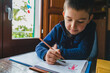 © Giorgio Magini/Stocksy - Focused Kid on Coloring Notebook at Home