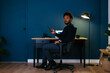 © BONNINSTUDIO/Stocksy - Black freelancer with smartphone sitting near desk