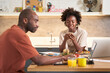 © Guille Faingold/Stocksy - Black couple working at breakfast table.