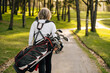 © Sergio Marcos/Stocksy - Anonymous Golfer woman carrying clubs