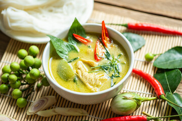 Wall Mural - Traditional green curry chicken cuisine asian food, Chicken green curry Thai food on soup bowl with ingredient vegetable herbs and spices pepper chili. Top view