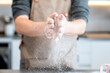 © Albert Martinez/Stocksy - Man spreading flour with the hands on a table