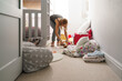 © Nadine Brandt/Stocksy - Cleaning lady tidying children's bedroom