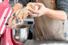 Man Removing Bread Dough From A Mixer