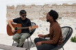 © Bisual Studio/Stocksy - Diverse men creating music on terrace