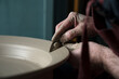© Albert Martinez/Stocksy - Man scraping the inside of a ceramic jug with a piece of metal