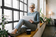 © Mihajlo Ckovric/Stocksy - Portrait of a senior businesswoman using her tablet in the office