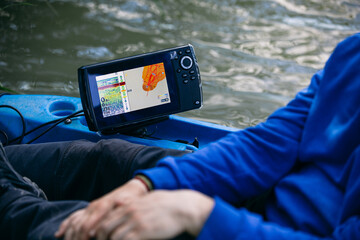 Crop fisherman using sonar on boat 