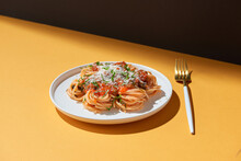 On A Light Yellow Background - In A Plate Of Spaghetti With Red Tomato Sauce, Cheese, Mint Leaves