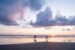 © Jennifer Bogle/Stocksy - Siblings play on sandy beach at sunset