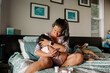 © Erin Brant/Stocksy - Asian mother on bed with sick daughter
