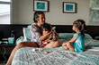 © Erin Brant/Stocksy - Deaf Asian mother tending to sick daughters