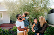 © Erin Brant/Stocksy - Happy biracial family outdoors with girls in matching outfits
