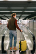 © Alina Hvostikova/Stocksy - Unrecognizable man walking on escalator in airport
