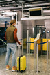 © Alina Hvostikova/Stocksy - Man with suitcase waiting near gates in airport