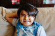 © Jimena Roquero/Stocksy - Hispanic 6-year old Kid at home looking at camera smiling