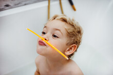 Boy Playing With Glow Sticks In The Bath Tub