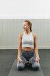 © Flamingo Images/Stocksy - Fit woman sitting on a yoga mat