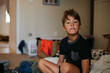 © Rob and Julia Campbell/Stocksy - Young boy inside home and bored